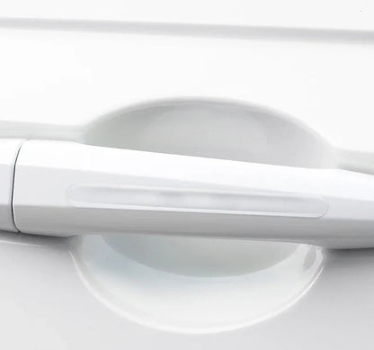 Clear silicone door bowl protector installed in recessed door handle bowl of white car