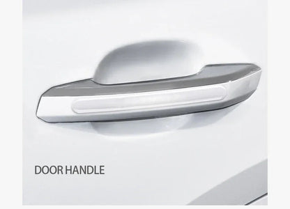 Clear silicone scratch guard applied to white car door handle, close-up view