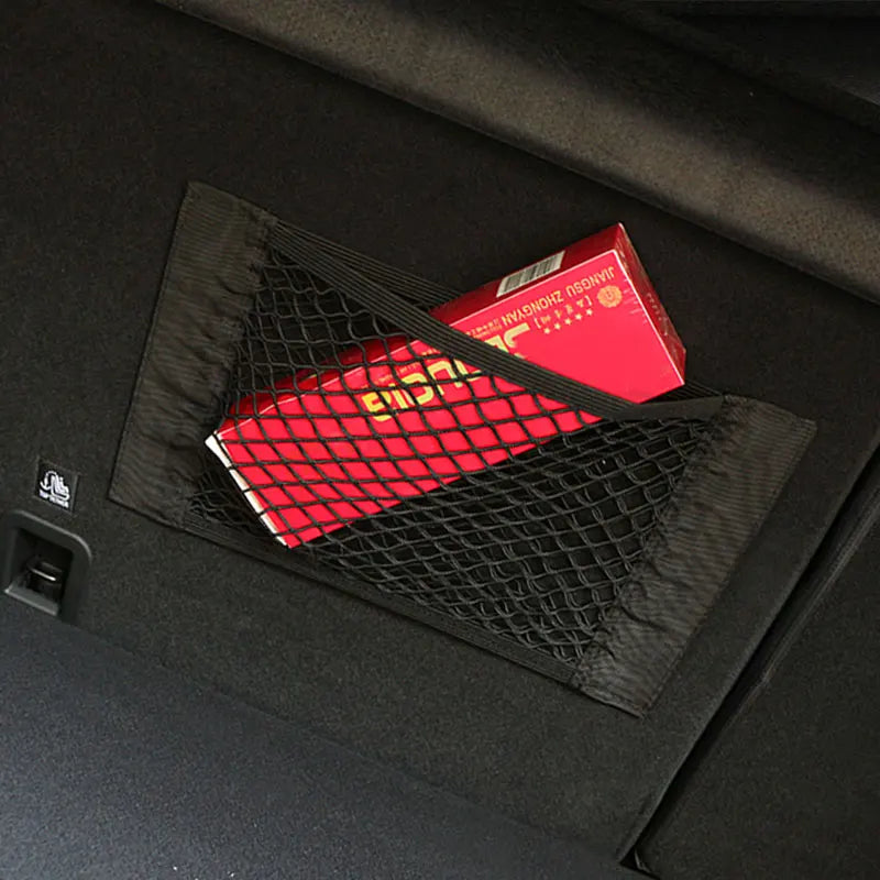 Trunk cargo net on car boot wall holding red gift boxes and packages